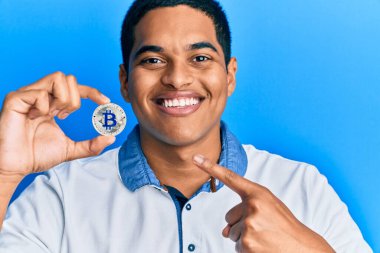 Genç, yakışıklı İspanyol adam elinde sanal para tutuyordu. Bitcoin gülümsüyordu. 