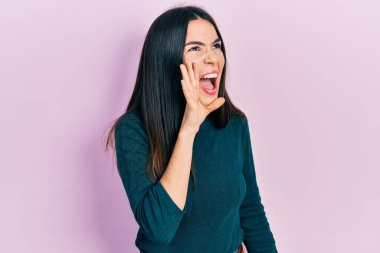 Kış süveteri giymiş genç esmer kadın el ele tutuşarak bağırıyor ve çığlık atıyordu. iletişim konsepti. 