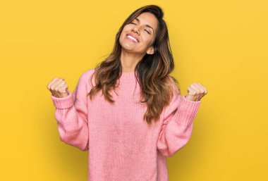 Genç İspanyol kadın gündelik kıyafetler giyiyor çok mutlu ve heyecanlı kazanan jestler yapıyor kolları havada, gülümsüyor ve başarı için bağırıyor. kutlama konsepti. 