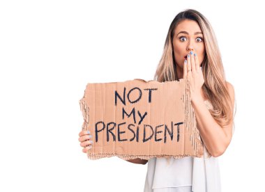 Genç, sarışın bir kadın, elinde benim başkanlık pankartımdan başka bir şey tutuyordu. Ağzı eliyle kaplıyordu. Şok olmuştu ve hata yapmaktan korkuyordu. şaşırmış ifade 