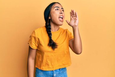 Gündelik giysiler giymiş genç Latin bir kadın el ele tutuşarak bağırıyor ve çığlık atıyordu. iletişim konsepti. 