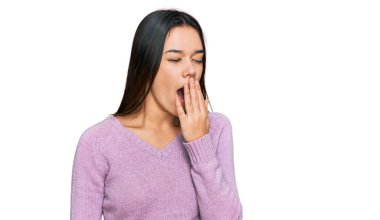 Günlük kıyafetler giyen genç İspanyol kız ağzıyla ağzını kapatmaktan sıkılmış. Huzursuz ve uykulu.. 