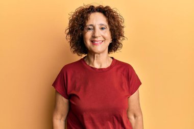 Güzel, orta yaşlı, normal giyinen olgun bir kadın. Pozitif ve mutlu görünüyor. Kendine güvenen bir gülümsemeyle dişlerini gösteriyor. 