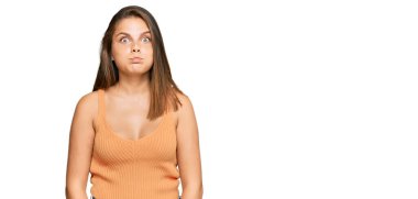 Gündelik kıyafetler giyen, komik yüzlü, yanak şişiren beyaz bir kadın. Havayla şişmiş ağız, çılgın bir ifade.. 