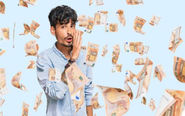 Latin asıllı genç adam, günlük kıyafetlerini giymiş, el ele tutuşmuş, gizli söylentiler yayıyor, kötü niyetli konuşmalar fısıldıyor.