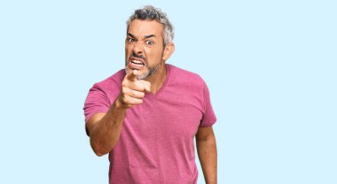 Orta yaşlı, gri saçlı, sıradan kıyafetler giyen ve kameraya kızgın ve sinirli olduğunu gösteren bir adam. 