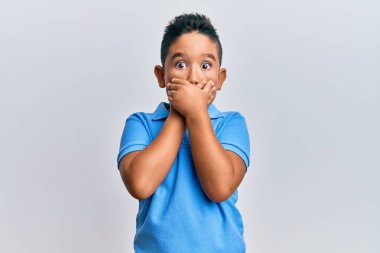 Günlük kıyafetler giyen küçük İspanyol çocuk yanlışlıkla elleriyle ağzını kapatırken şok oldu. gizli kavram. 