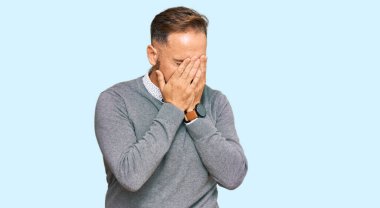 Yakışıklı, orta yaşlı, iş kıyafetleri giyen, suratını ellerle örten, ağlayan bir adam. depresyon kavramı. 