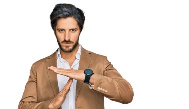 İş kıyafetleri giymiş genç İspanyol bir adam. El kol hareketleri yapıyor. Hayal kırıklığına uğramış ve ciddi bir yüz ifadesi takınıyor. 