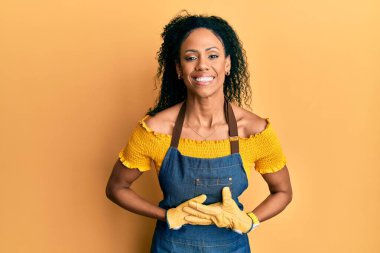 Orta yaşlı Afro-Amerikalı kadın profesyonel önlük giyip kahkahalarla gülüyor.. 