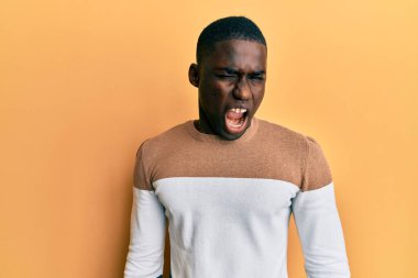 Genç Afro-Amerikalı sıradan kıyafetler giymiş, kameraya seksi bir ifadeyle bakıyor, neşeli ve mutlu bir yüzle.. 