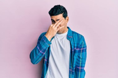 Yakışıklı, sıradan kıyafetler giyen, pis ve iğrenç bir koku alan, nefesini burnunda tutan İspanyol bir adam. Kötü kokuyor. 