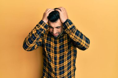 İspanyol asıllı genç adam gündelik giysiler giyiyor. Baş ağrısı çekiyor. Acı ve migren yüzünden çaresiz ve stresli. Eller başının üstünde.. 