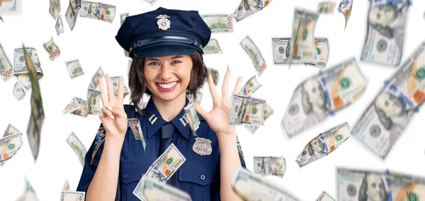 Young beautiful girl wearing police uniform showing and pointing up with fingers number eight while smiling confident and happy.
