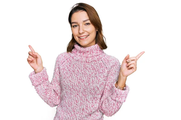 若い白人の少女は ウールの冬のセーターを着て 自信を持ってさまざまな方向に指で指して笑顔 広告のコピースペース — ストック写真