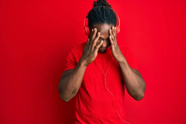 ストレスのために頭の上に手でヘッドフォンを使用して音楽を聞いているアフリカ系アメリカ人の男性 片頭痛 — ストック写真