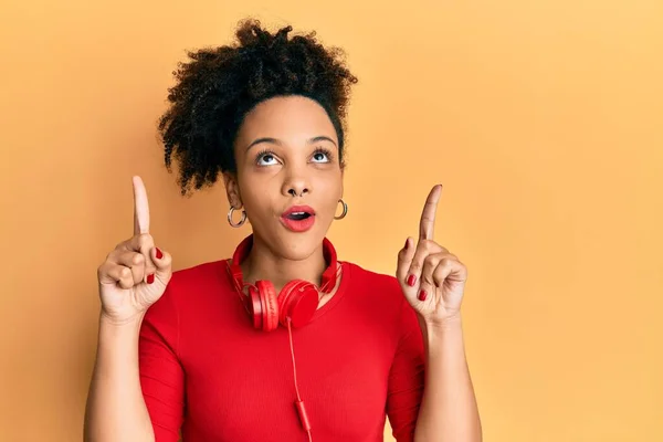 Joven Afroamericana Americana Escuchando Música Usando Auriculares Asombrada Sorprendida Mirando —  Fotos de Stock