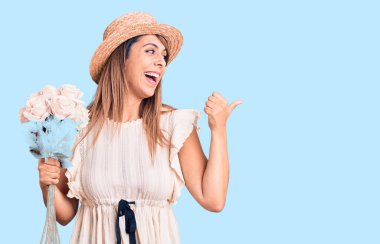 Şapkalı güzel bir kadın elinde bir buket çiçekle baş parmağını kaldırmış, ağzı açık bir şekilde gülümsüyor. 