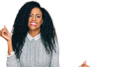 Orta yaşlı Afro-Amerikalı kadın günlük kıyafetler giyip farklı yönleri gösteren kendine güvenle gülümsüyor. reklam için kopyalama alanı 