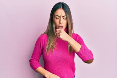 Günlük kıyafetler giyen genç İspanyol kadın kendini iyi hissetmiyor ve soğuk algınlığı veya bronşitin belirtisi olarak öksürüyor. sağlık hizmeti kavramı. 