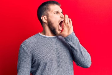 Genç, yakışıklı bir adam gündelik kazak giyip el ele tutuşarak bağırıyor ve çığlık atıyordu. iletişim konsepti. 