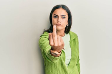 Young brunette woman wearing casual clothes showing middle finger, impolite and rude fuck off expression 