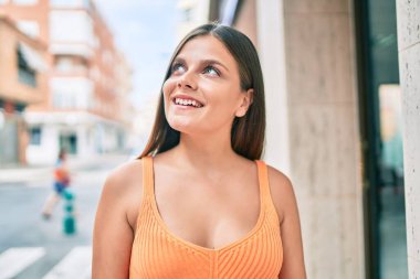 Genç ortadoğu kızı gülümseyerek şehirde mutlu mesut yürüyor..