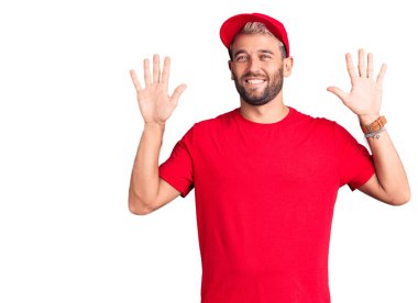 Tişört ve şapka giyen genç sarışın adam on numarayı gösterip işaret ederken kendinden emin ve mutlu gülümsüyor.. 