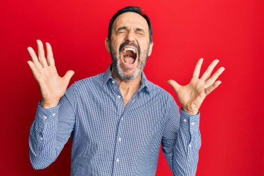 Orta yaşlı İspanyol bir adam, gündelik kıyafetler giyip başarı için deli ve çılgınlığı kutluyor. Kolları havada ve gözleri kapalı, heyecanlı bir şekilde bağırıyor. Kazanan konsept 