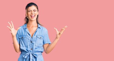 Gündelik giysiler giyen genç, çılgın ve çılgın başarıyı kutlayan kollarını kaldırmış, gözlerini kapatmış heyecanlı çığlıklar atan bir kadın. Kazanan konsept 