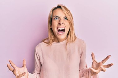 Güzel sarışın kadın, sıradan bir kazak giyiyor. Deli gibi bağırıyor, agresif bir ifadeyle bağırıyor ve kollarını kaldırıyor. hüsran kavramı. 