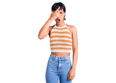 Kısa saçlı, esmer bir kadın. Günlük kıyafetler giymiş. Şoka girmiş, yüzünü ve gözlerini kapamış, utangaç ifadesiyle parmaklarından bakıyor.. 