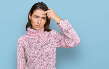 Kafkasyalı, yün kazak giyen genç bir kız alnındaki sivilceden mutsuz, siyah noktalı çirkin bir enfeksiyon taşıyor. sivilce ve deri problemi 