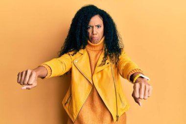 Orta yaşlı Afro-Amerikan kadın motosiklet sembolü yapıyor elleri depresif ve endişe içinde, kızgın ve korkmuş. hüzünlü ifade. 