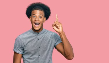 Afro saçlı, sıradan giyinmiş, başarılı bir fikri işaret eden Afro-Amerikalı bir adam. Heyecanlı ve mutlu. Bir numara.. 