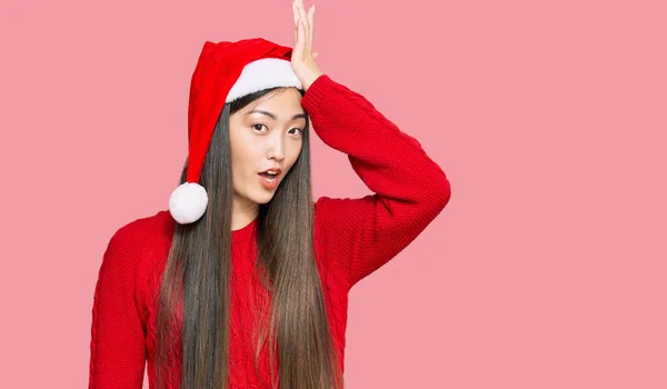若い中国の女性は間違いのために頭の上に手で驚いてクリスマスの帽子をかぶって エラーを覚えている 忘れられた悪い記憶の概念 — ストック写真