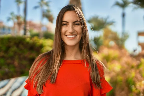 Genç İspanyol kadın parkta mutlu bir şekilde gülümsüyor..