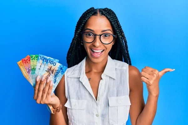 Hermosa Mujer Hispana Sosteniendo Billetes Franco Suizos Apuntando Con Pulgar —  Fotos de Stock