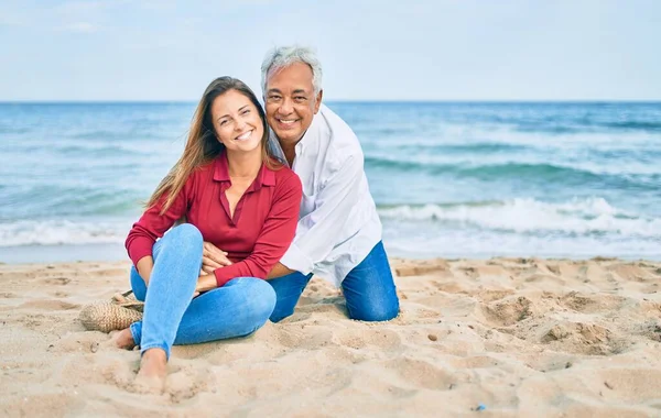 Medelåldern Hispanic Par Ler Glad Och Kramas Sitter Stranden — Stockfoto