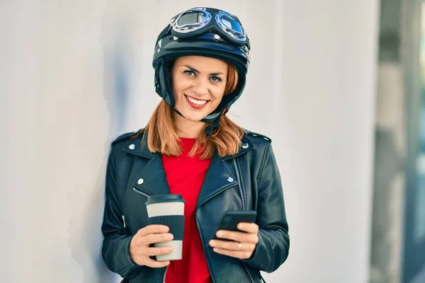 若いですラテン女性身に着けていますオートバイヘルメットを使用してスマートフォンで市 — ストック写真