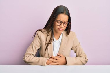 Ofiste çalışan güzel İspanyol bir kadın midesi üzerinde çalışıyor çünkü hazımsızlık, acı verici bir hastalık kendini iyi hissetmiyor. Ağrı kavramı. 