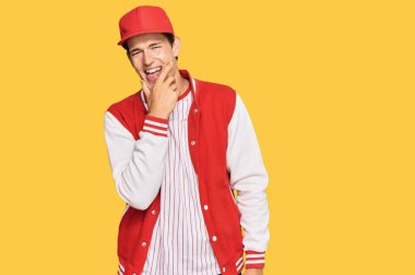 Beyzbol üniforması giyen yakışıklı beyaz adam kameraya bakıyor kollarını kavuşturup gülümsüyor ve çenesini kaldırıyor. Olumlu düşünmek. 