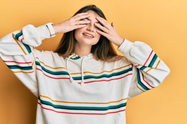 Kafkasyalı genç bir kadın günlük kıyafetler giyiyor. Gözleri kapatıyordu. Neşeli ve komik gülümsüyordu. kör kavram. 