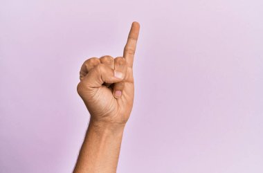 Pembe izole edilmiş arka planda beyaz bir gencin kolu ve eli serçe parmağının söz verme sözü olduğunu gösteriyor. Bir numara: 