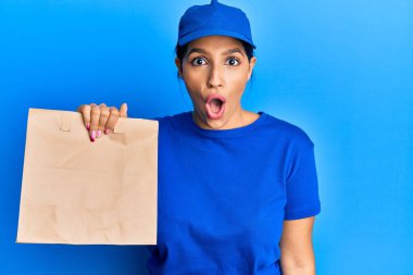 Elinde paket kağıdı tutan güzel esmer kadın ağzı açık kalmış, korkmuş ve hayrete düşmüştü. 