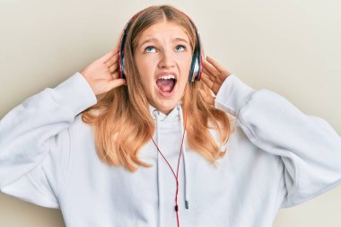 Güzel, genç, beyaz bir kız. Kulaklık takıp müzik dinliyor. Öfkeli ve öfkeli çığlıklar atıyor.. 