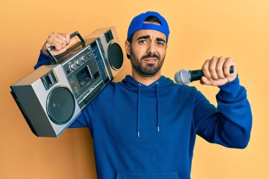 Kasetçalar tutan genç İspanyol adam mikrofondan habersiz ve kafası karışmış bir ifadeyle müzik dinliyor. şüphe kavramı. 