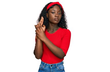 Güzel Afrikalı genç bir kadın gündelik giysiler giyip elinde sembolik bir silahla el hareketleriyle cinayet silahlarıyla ateş ediyor ve kızgın bir yüz ifadesi takınıyor. 