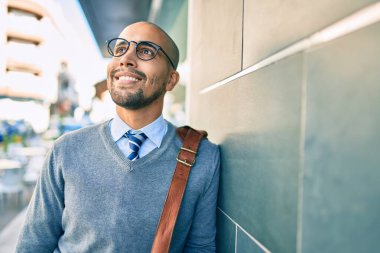 Genç Afrikalı Amerikalı iş adamı gülümsüyor. Şehrin duvarına yaslanmaktan mutlu..