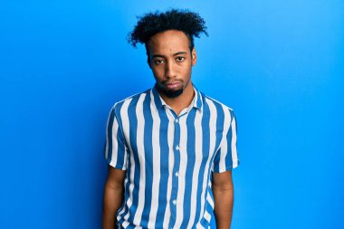 Sakallı, sıradan çizgili tişörtlü, kederli, sinirli ve korkmuş genç Afro-Amerikalı bir adam. hüzünlü ifade. 